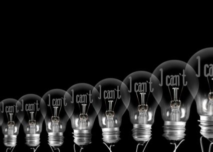 Large group of shining and dimmed light bulbs with fibers in a shape of I Can't and I Can words isolated on black background; concept of Motivation, Positivity and Change